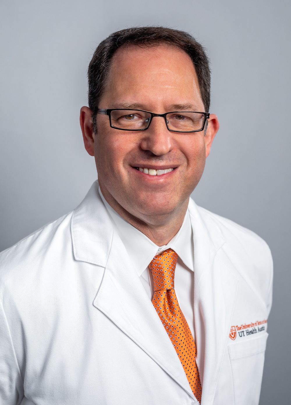 Pediatric cardiologist Daniel Stromberg, MD, earing a white coat and smiling in front of a white backdrop.