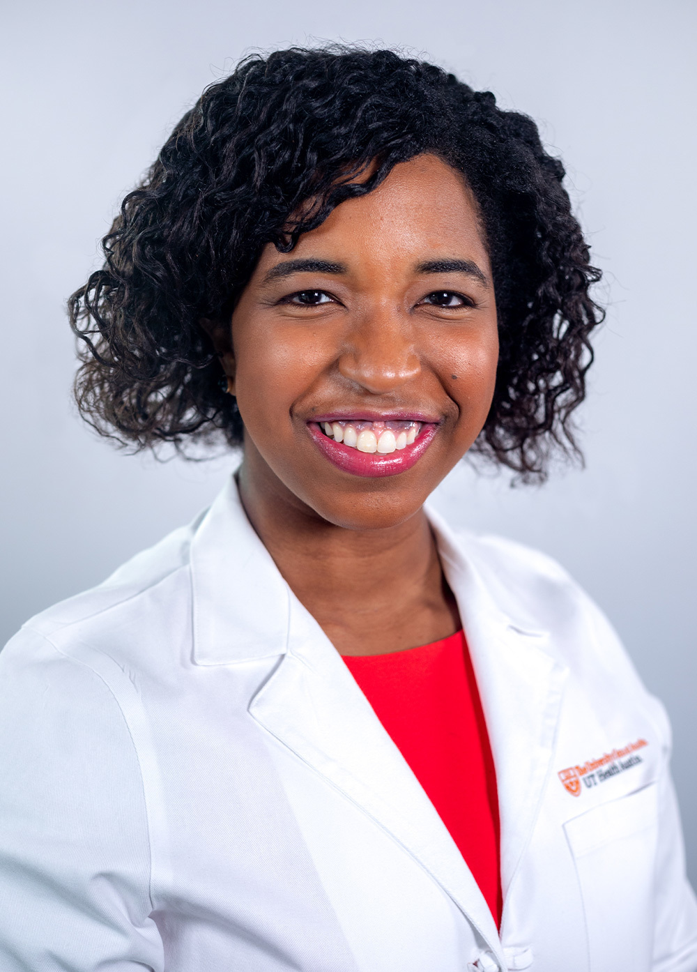 Obstetrician-gynecologist Denise Johnson, MD, wearing a white coat and smiling in front of a white backdrop.