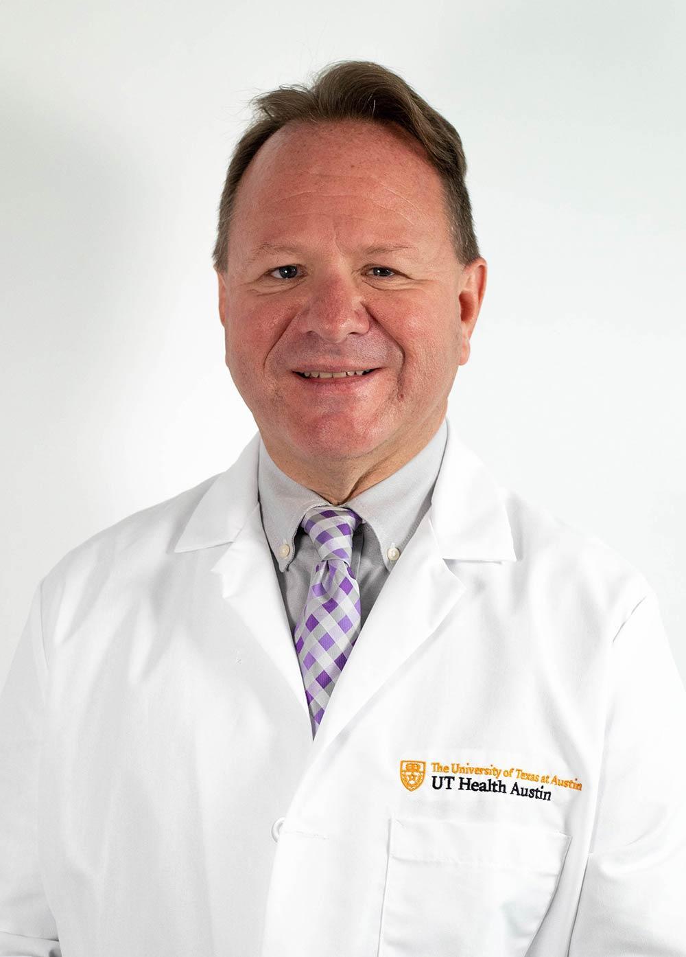 Dr. D. Jeffrey Newport wearing a white coat and smiling in front of a white backdrop.