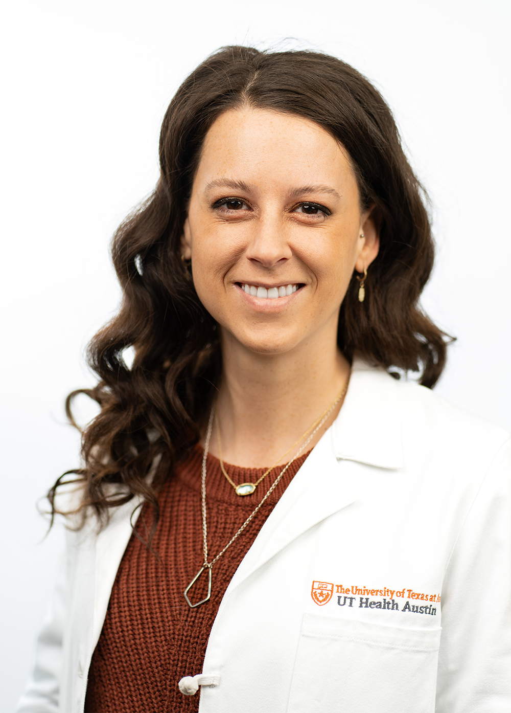 Pediatric cardiologist Jennifer Lehmberg, MD, wearing a white coat and smiling in front of a white backdrop.