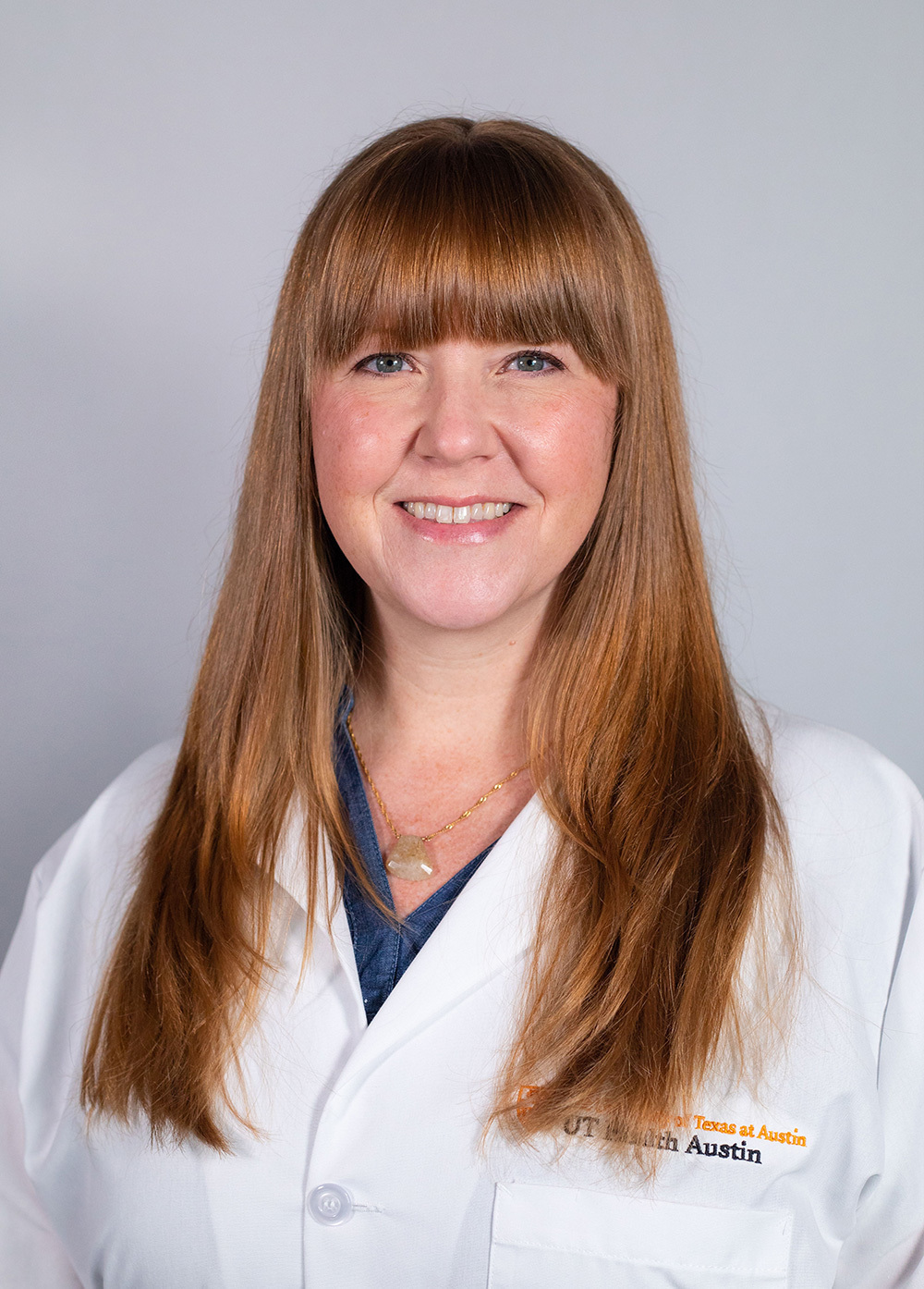 Pediatric nurse practitioner Jennifer Farley, RN, MSN, wearing a white coat and smiling in front of a white backdrop.