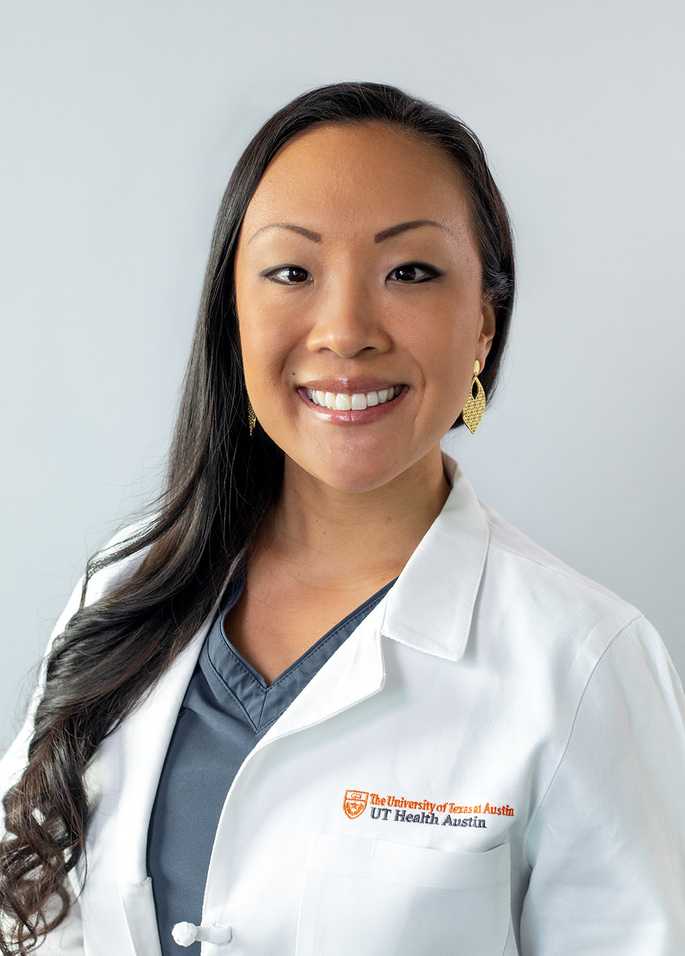 Jessica Hovland wearing a white coat and smiling in front of a white backdrop.