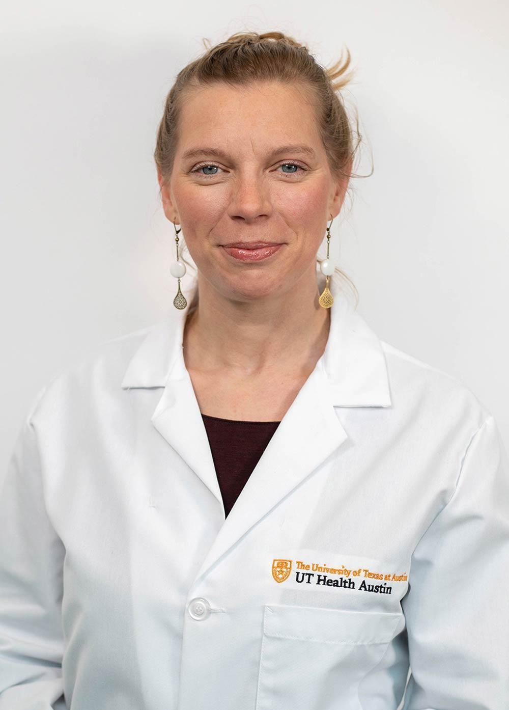 Pediatric epileptologist Kristina Jülich, MD, wearing a white coat and smiling in front of a white backdrop.