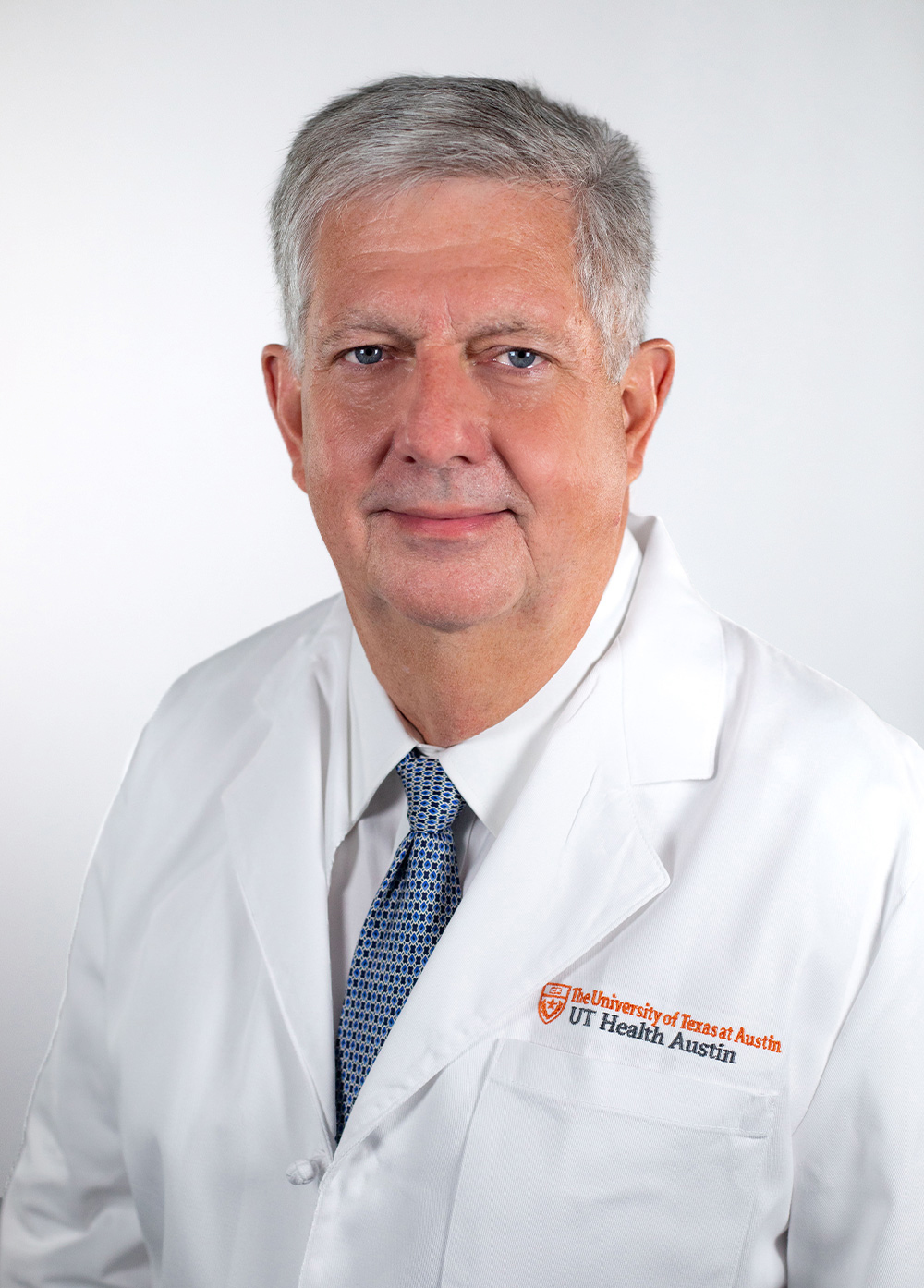 Dr. Kenneth J. Moise, Jr., wearing a white coat and smiling in front of a white backdrop.