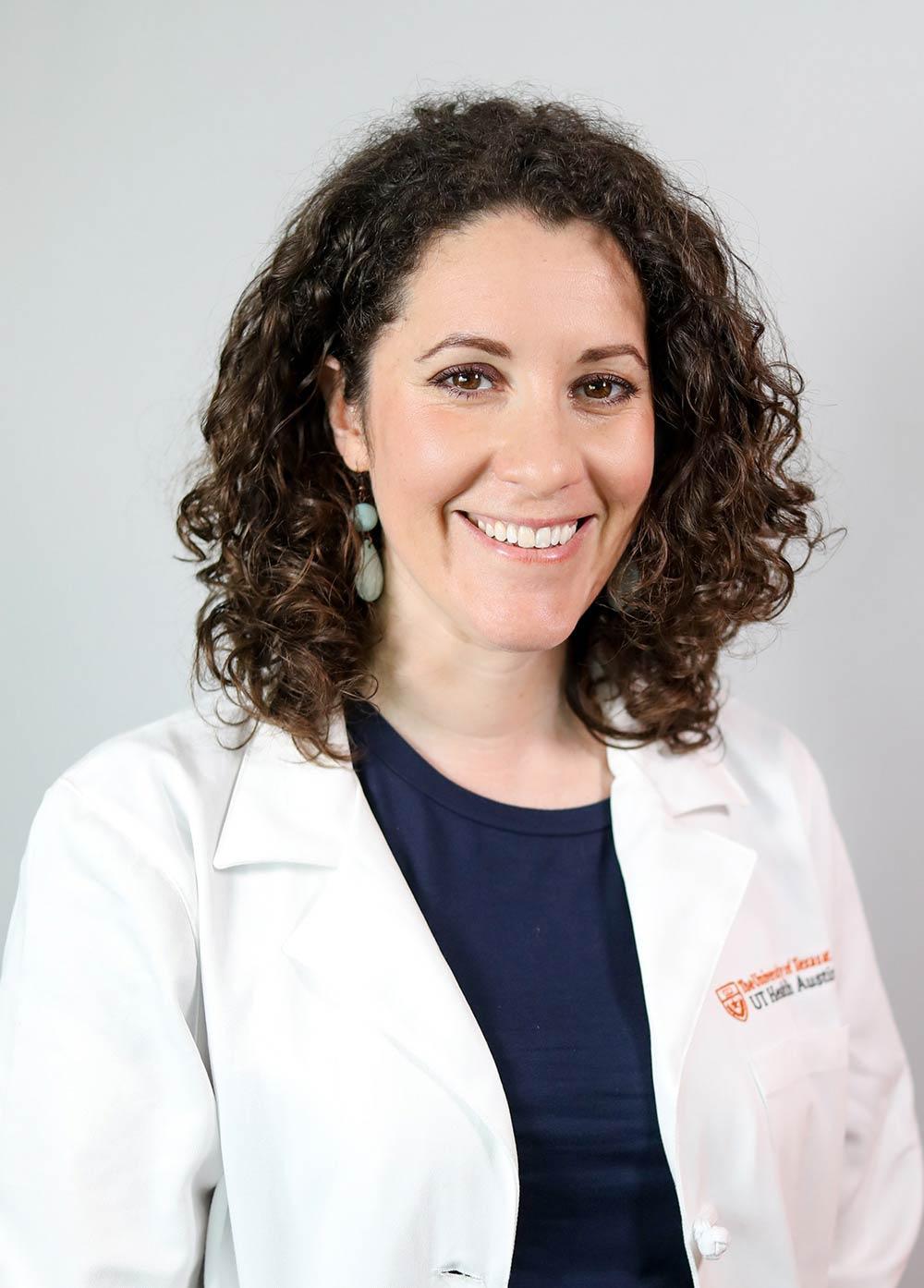 Dr. Leoráh Freeman wearing a white coat and smiling in front of a white backdrop.