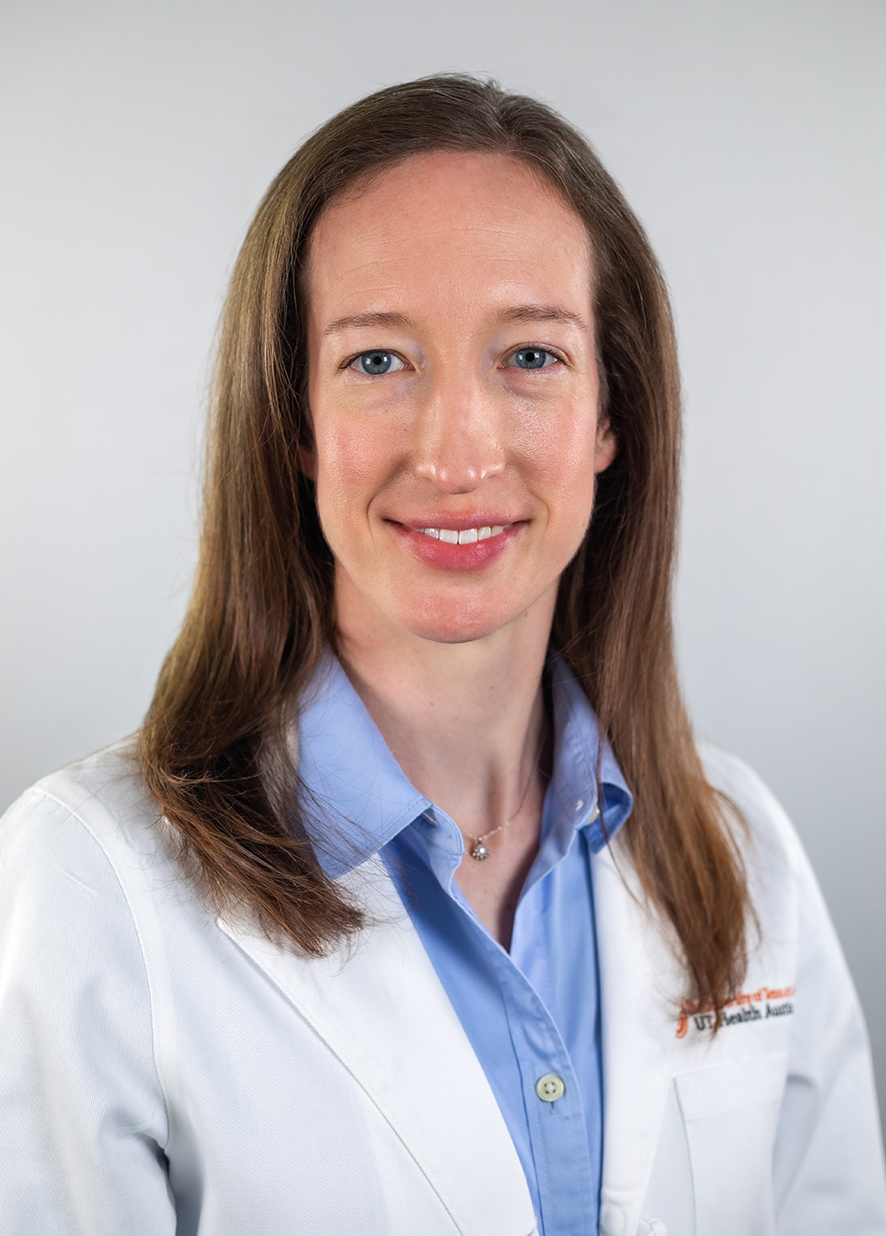 Pediatric neurologist Louisa Keith, MD, wearing a white coat and smiling in front of a white backdrop.