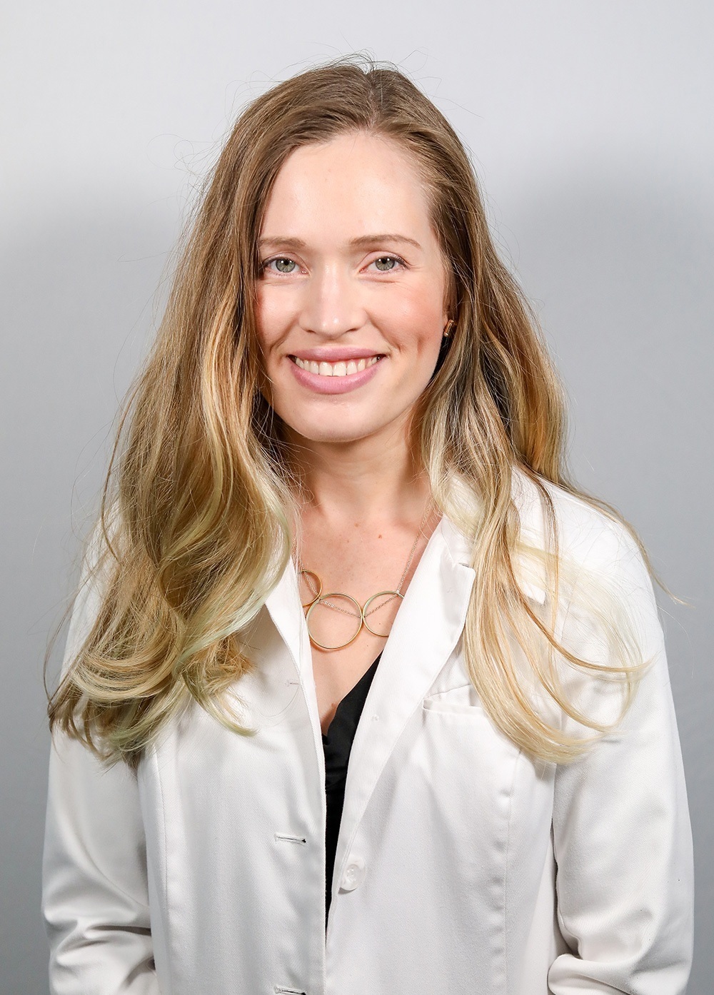 Pediatric psychiatrist Michele Lagrone, MD, MBA, wearing a white coat and smiling in front of a white backdrop.