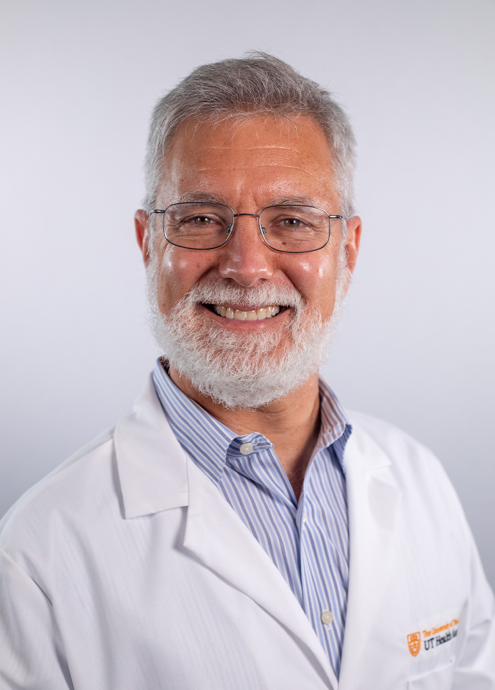 Urologist J. Stuart Wolf, Jr., MD, FACS, wearing a white coat and smiling in front of a white backdrop.