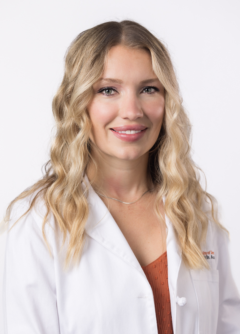 Alexandra Rossi, FNP-BC, wearing a white coat and smiling in front of a white background.