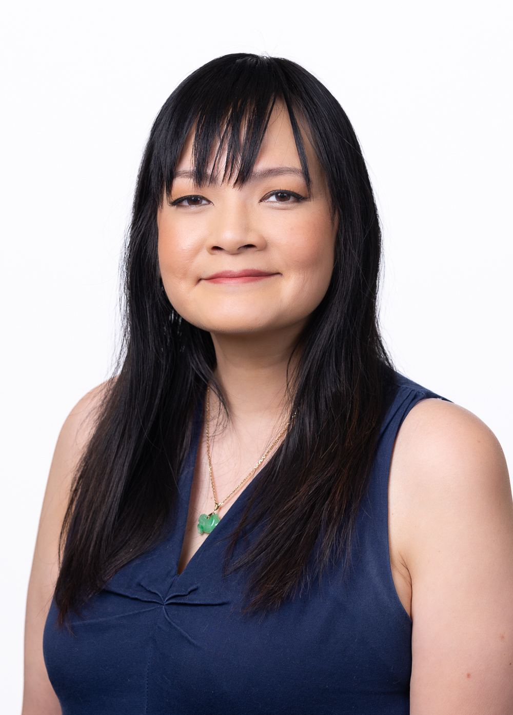 Licensed professional counselor supervisor Amy Tao Foster, LPC-S , wearing a navy blouse and smiling in front of a white backdrop.