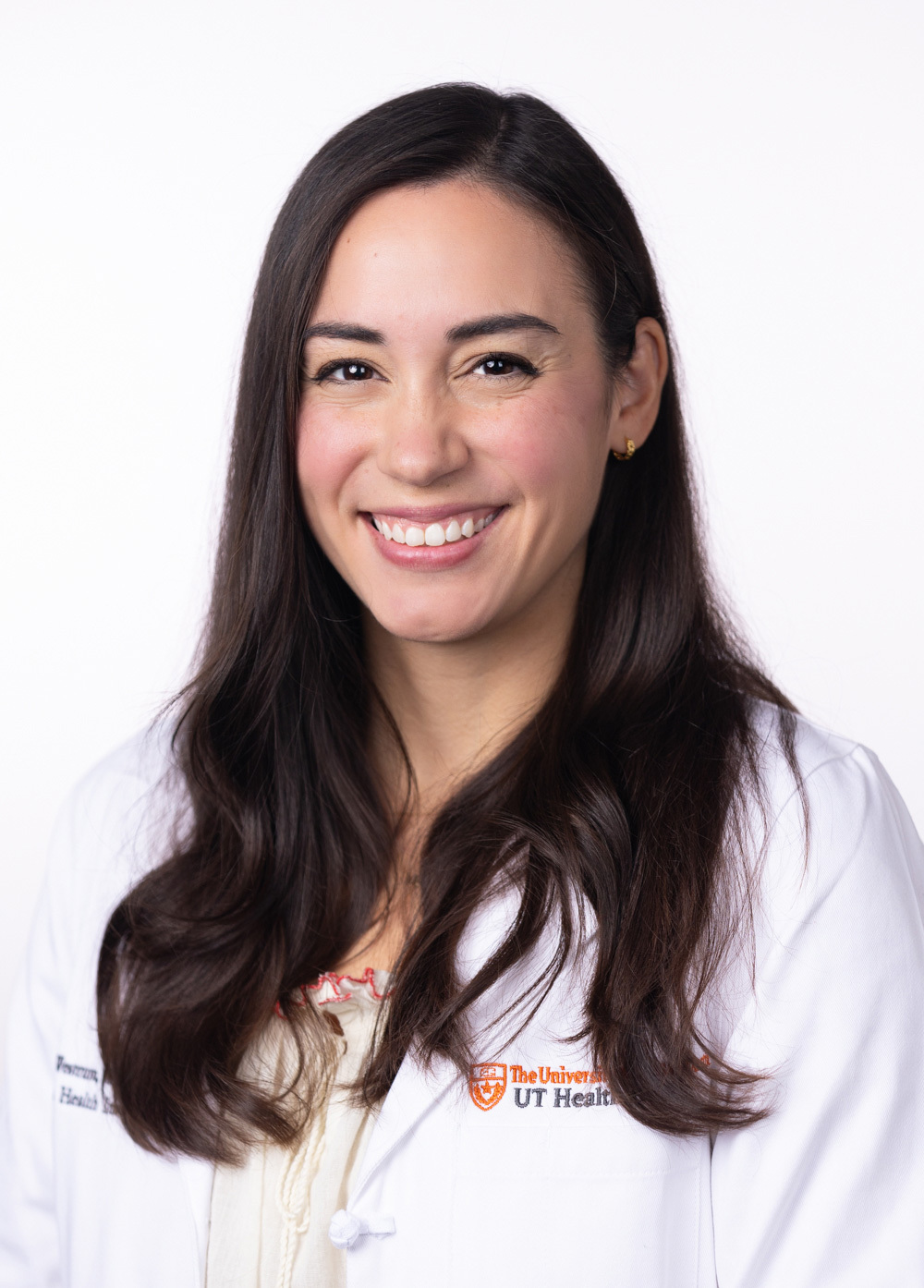 Physician assitant Ashley M. Westrum, MPAS, PA-C, wearing a white coat and smiling in front of a white background.