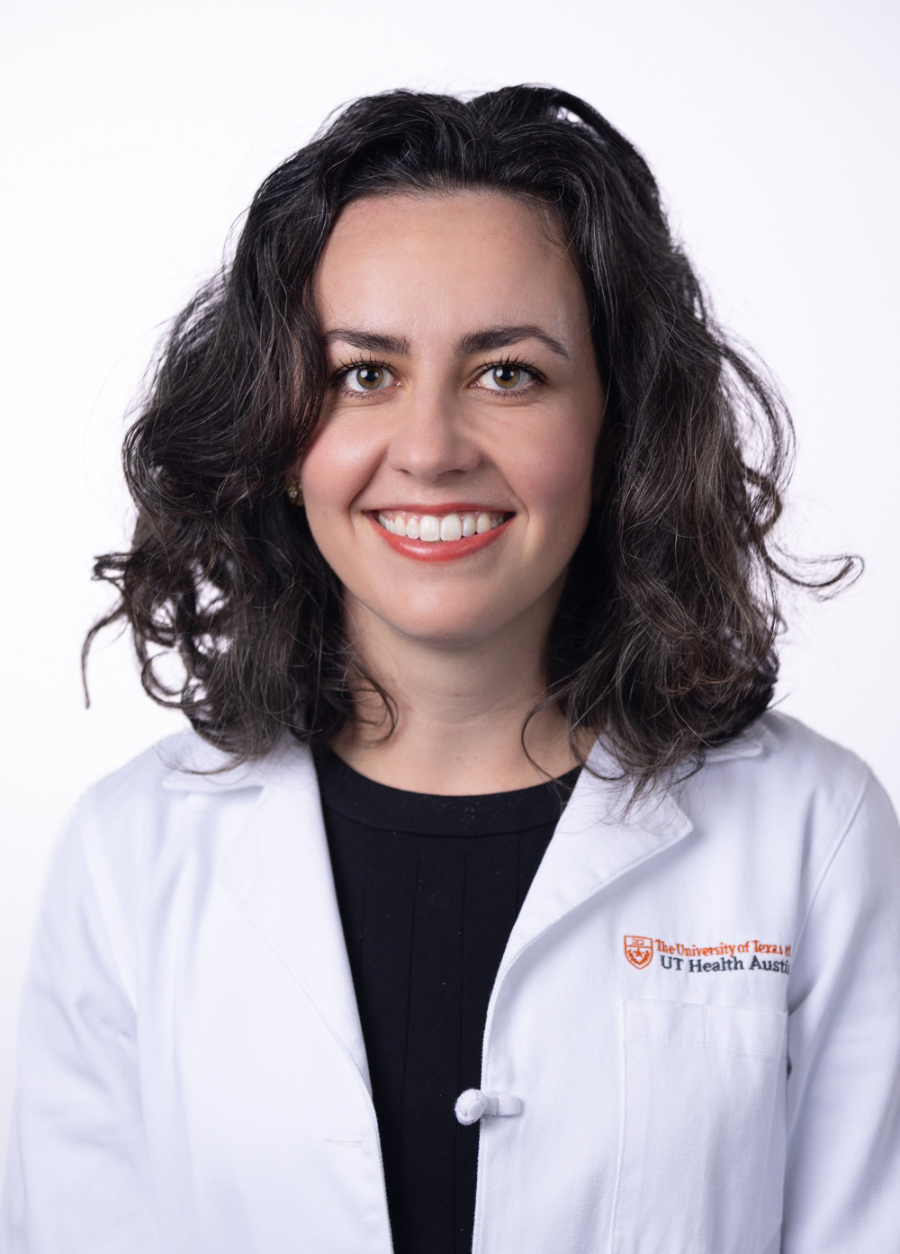 Internal medicine specialist Claire Harrison, MD stands in front of a white background smiling