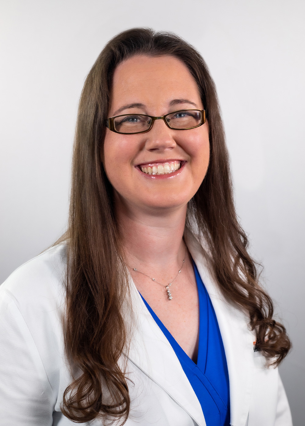 Dr. Cynthia Austin wearing a white coat and smiling in front of a white backdrop.