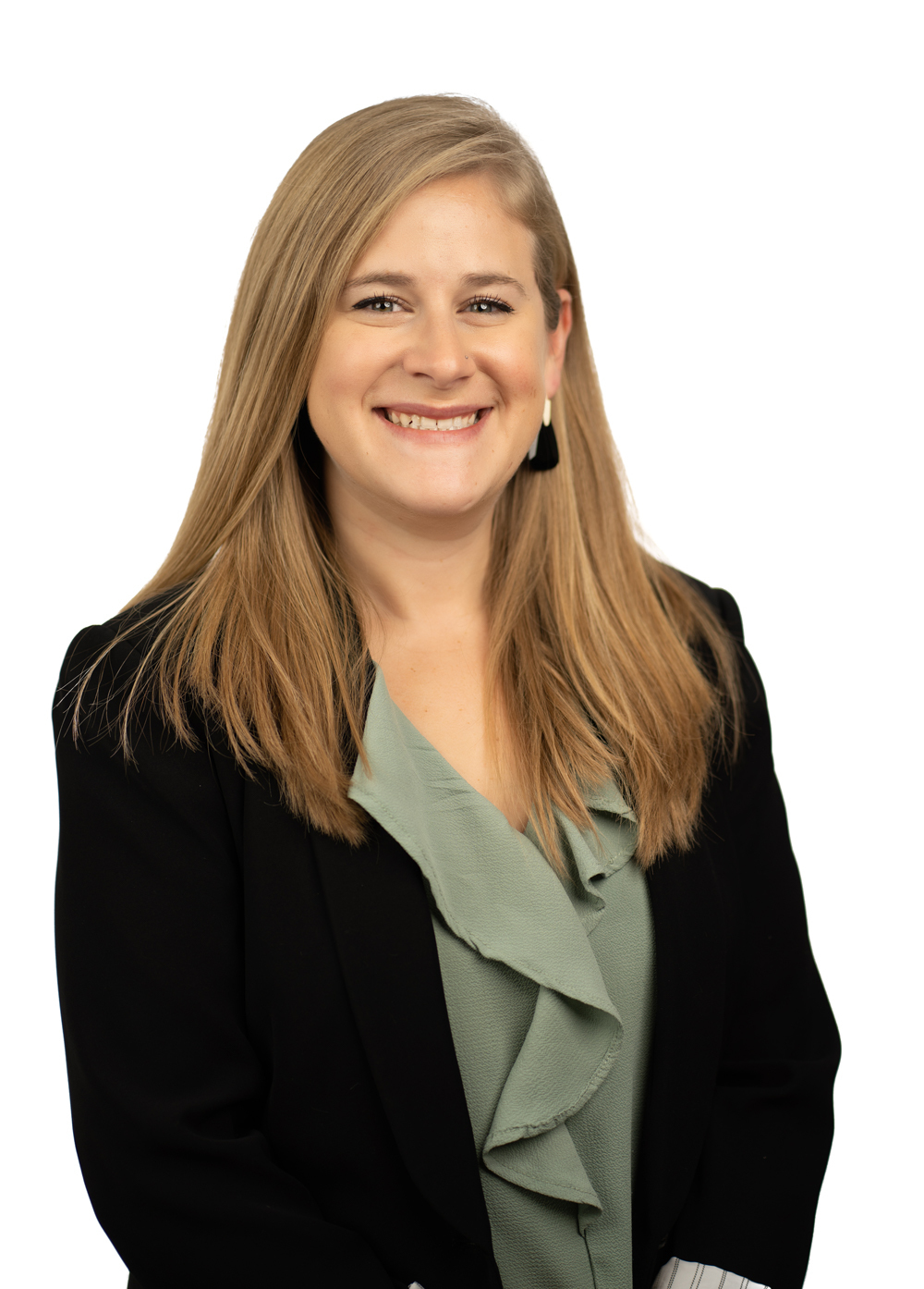 Daniela McFarland, LCSW, wearing a green blouse, black blazer, and smiling in front of a white backdrop.