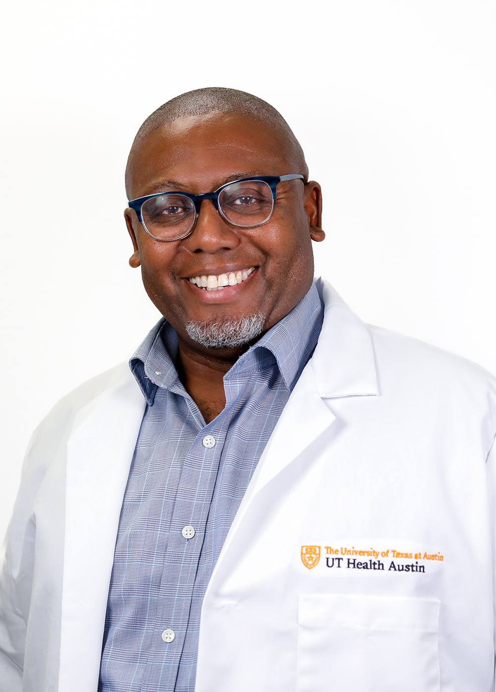 Pediatric epileptologist Dave Clarke, MD, wearing a white coat and smiling in front of a white backdrop.