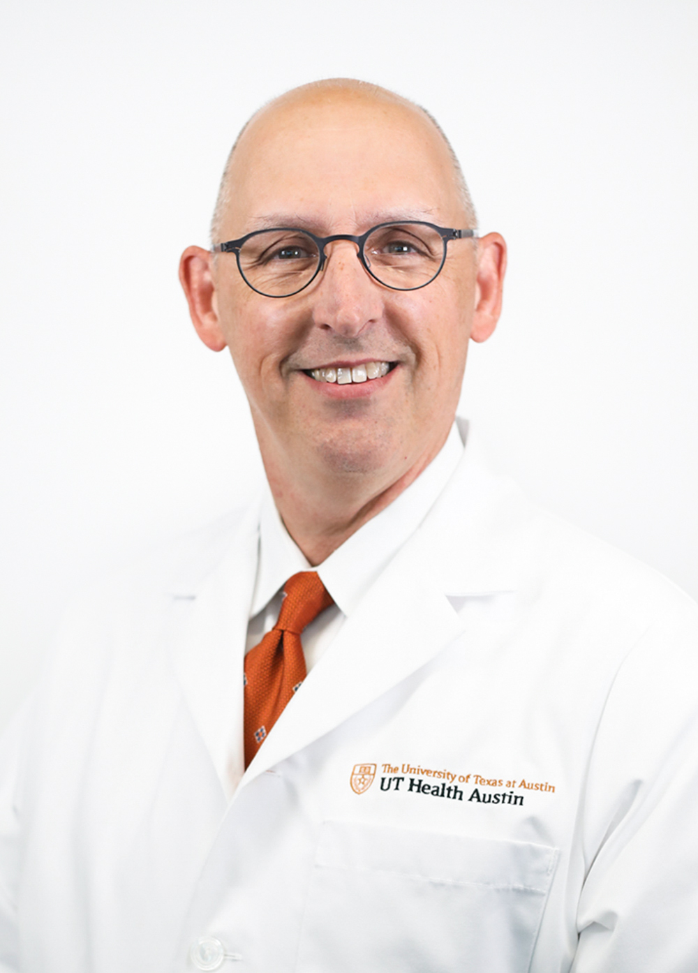 Dr. Declan Fleming wearing a white coat and smiling in front of a white backdrop.