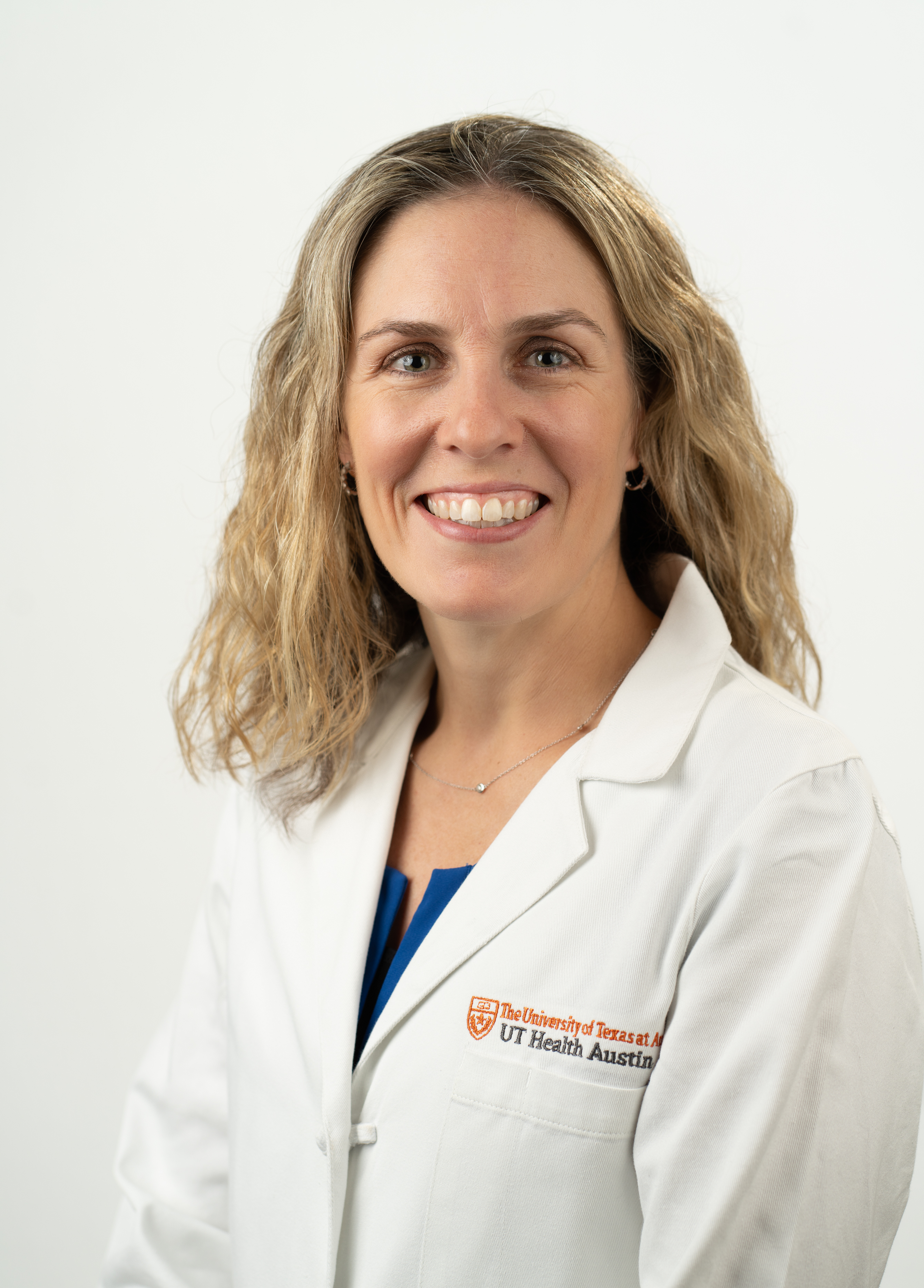 Pediatric and fetal cardiologist Eileen Stewart, MD, wearing a white coat and smiling in front of a white background.