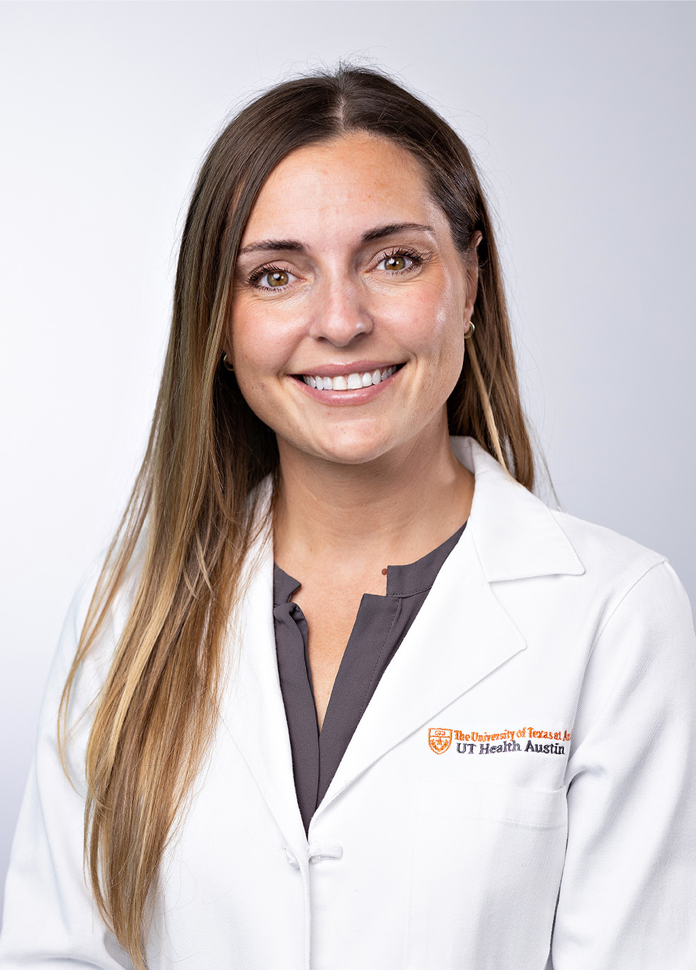 Surgeon Elisa Furay, MD, wearing a white coat and smiling in front of a white backdrop.