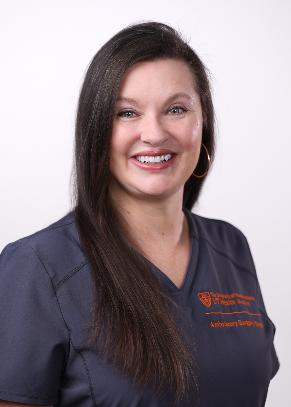 Registered nurse Elizabeth Freeman, BSN, RN, AAS, wearing dark scrubs and smiling in front of a white backdrop.