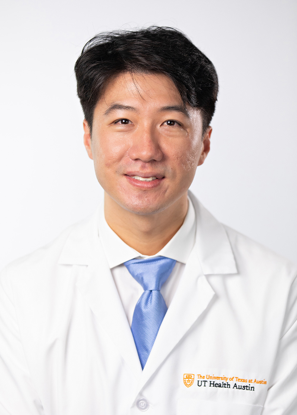 Ophthalmologist Gene Kim, MD, wearing a white coat and smiling in front of a white backdrop.