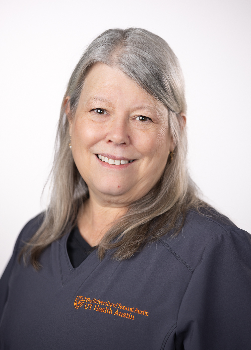 Gretchen Davenport, RN, wearing dark scrubs and smiling in front of a white backdrop.