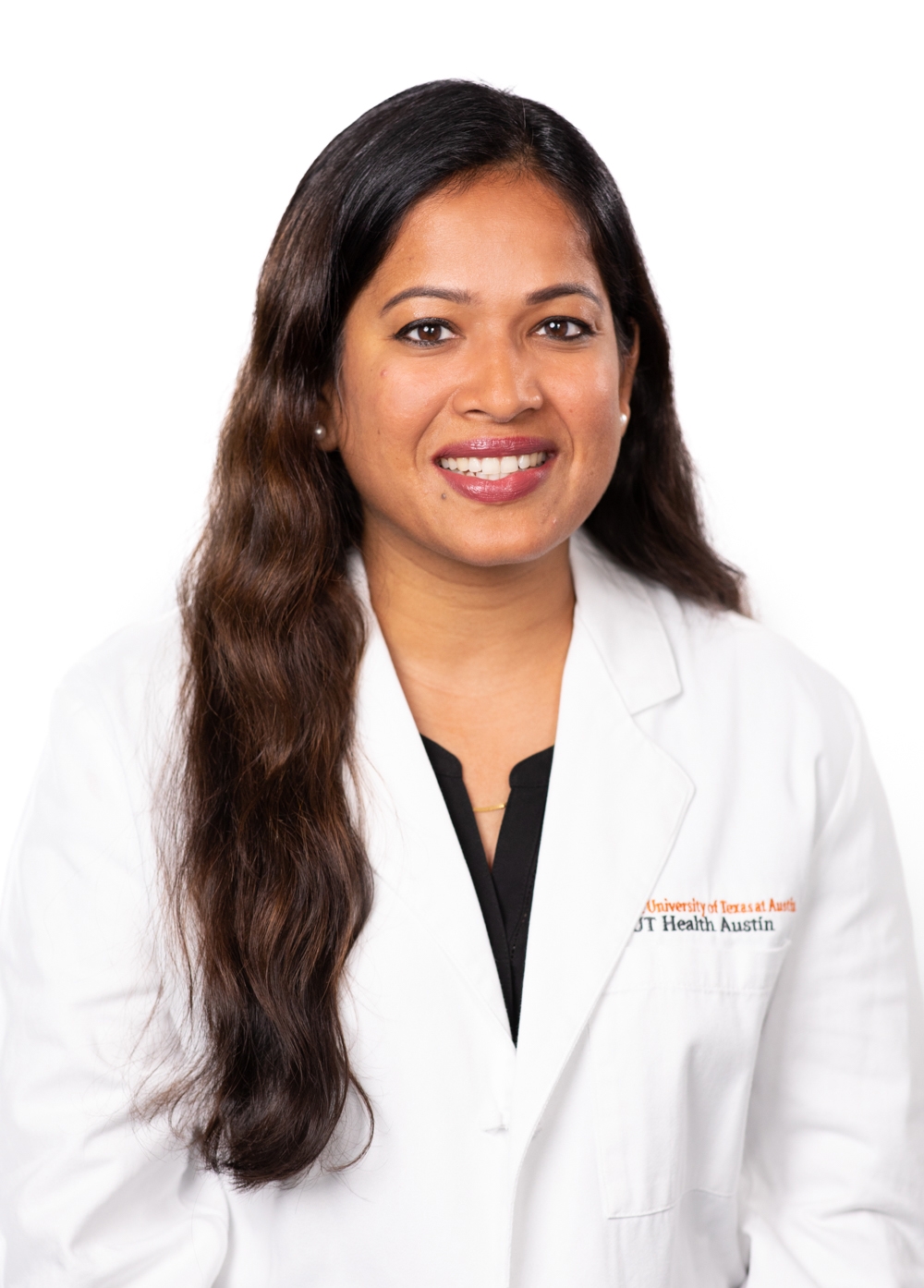 Dr. Gunjan Dokania wearing a white coat and smiling in front of a white backdrop.