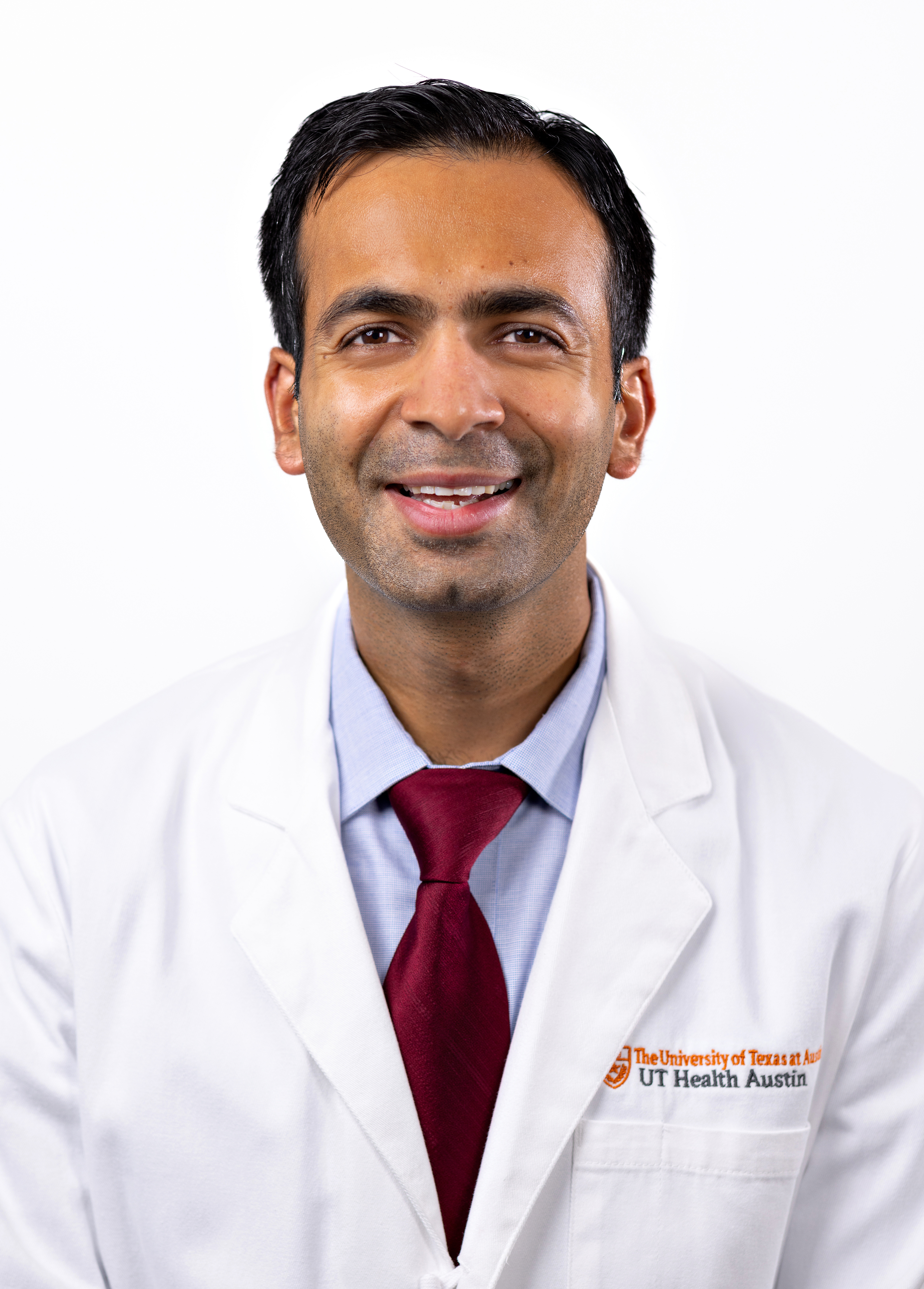 Interventional cardiologist Hitesh Agrawal, MD, wearing a white coat and smiling in front of a white backdrop.