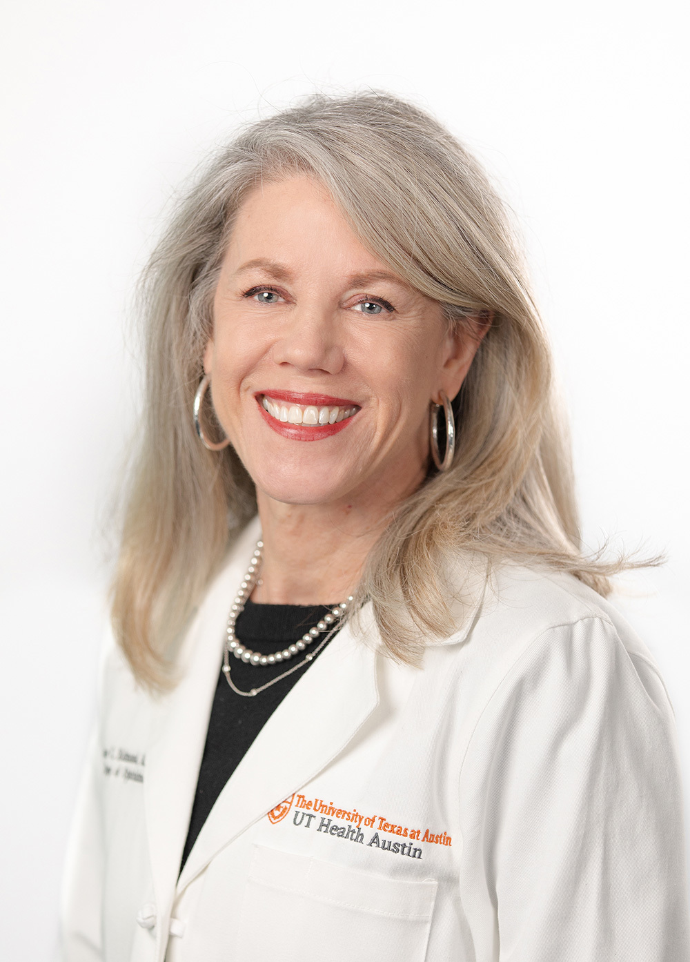 Pediatric neuro-ophthalmologist Jane C. Edmond, MD, wearing a white coat and smiling in front of a white backdrop.