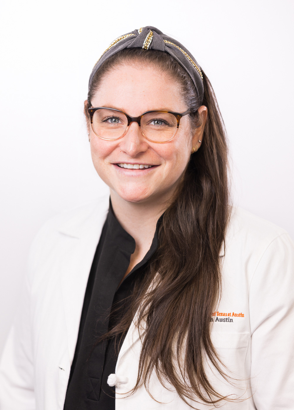 Acute care pediatric nurse practitioner Jennifer Sear, MSN, CPNP-AC, wearing a white coat and smiling in front of a white backdrop.