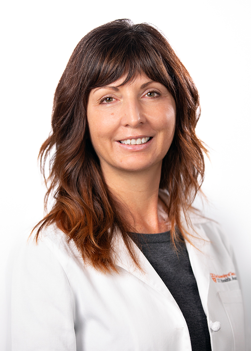 Jessica Richman wearing a white coat and smiling in front of a white backdrop.