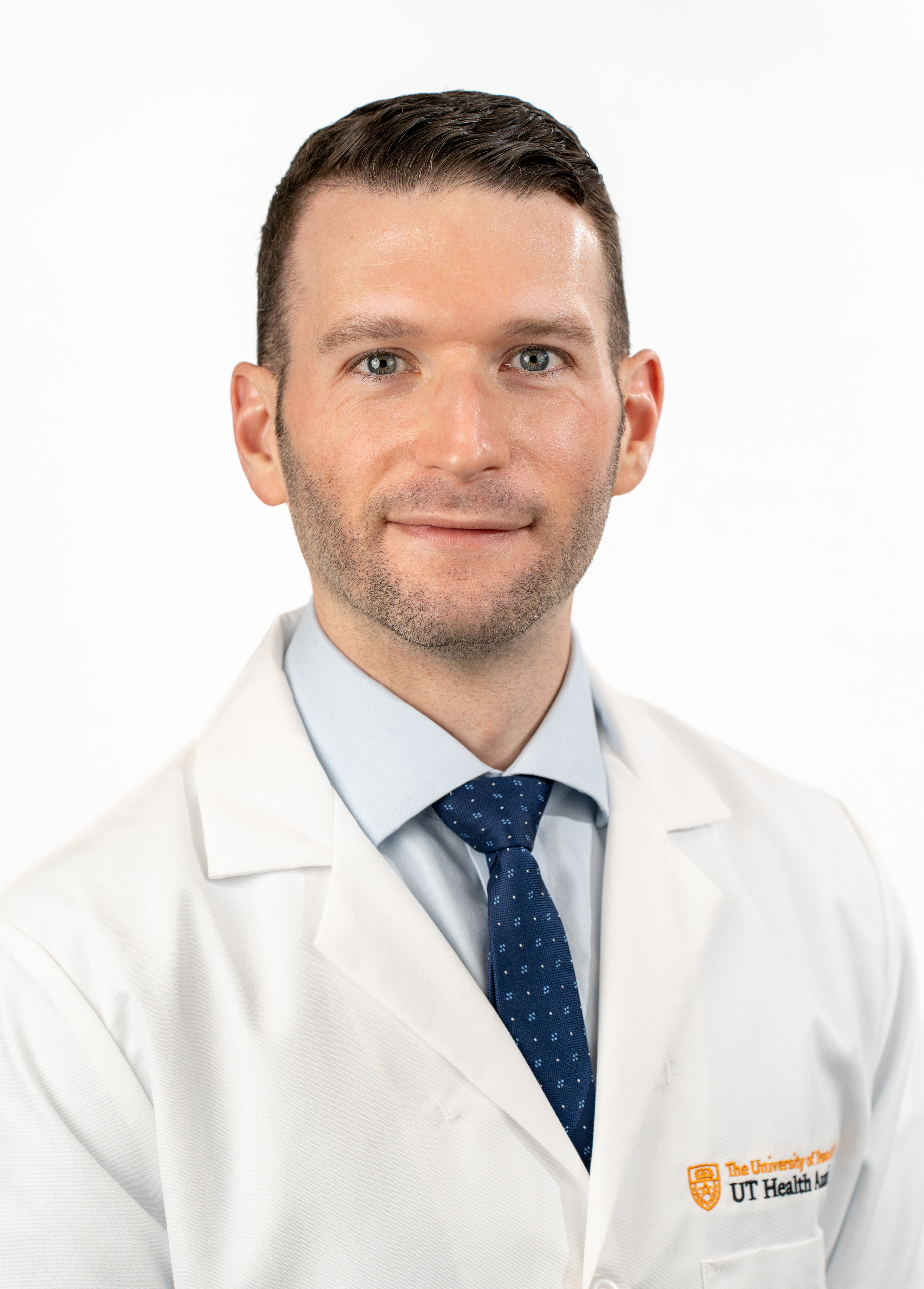 Cardiothoracic surgeon Joshua Grimm, MD, wearing a white coat and smiling in front of a white backdrop.