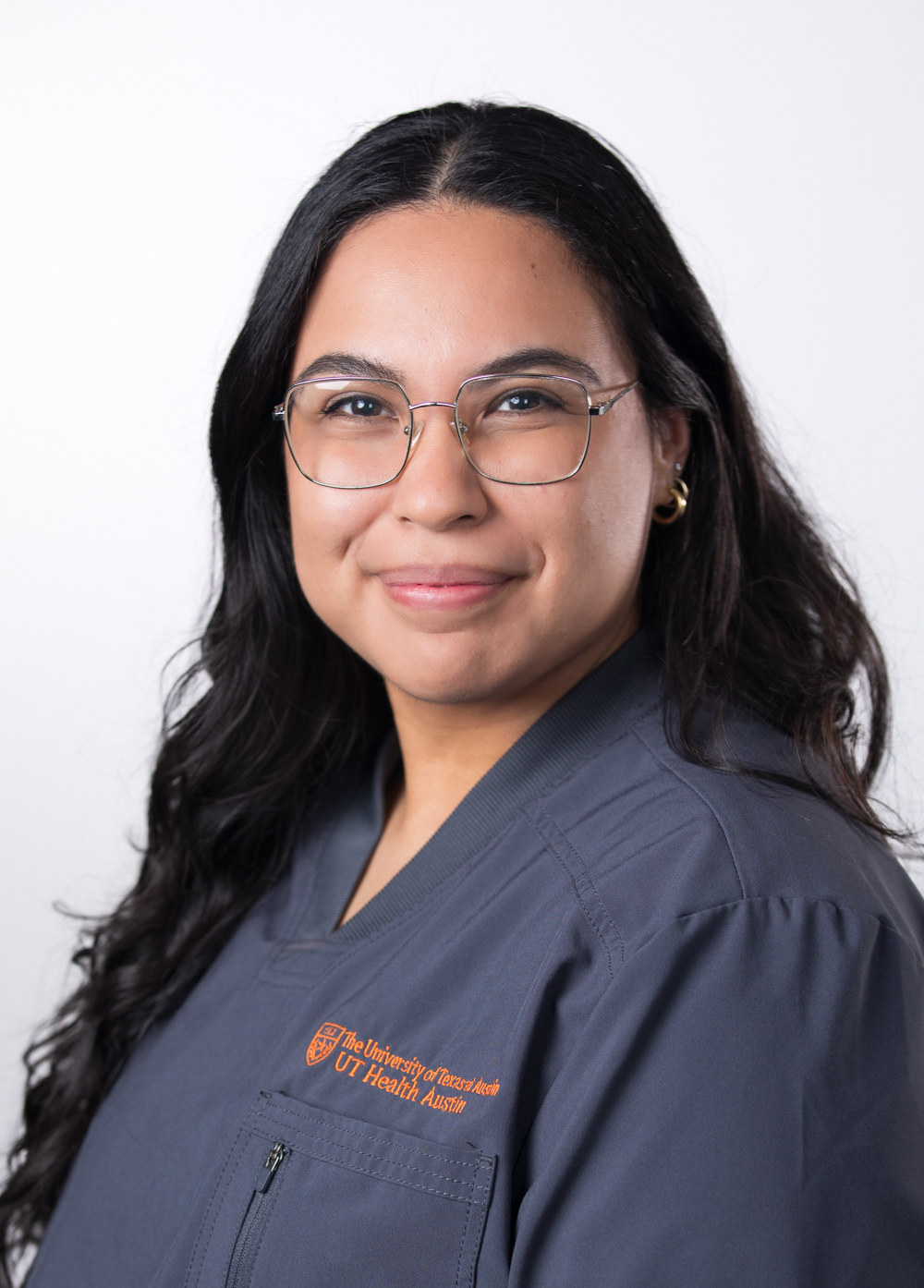 Registered nurse Karla Lopez, BSN, RN, wearing gray scrubs and smiling in front of a white backdrop.