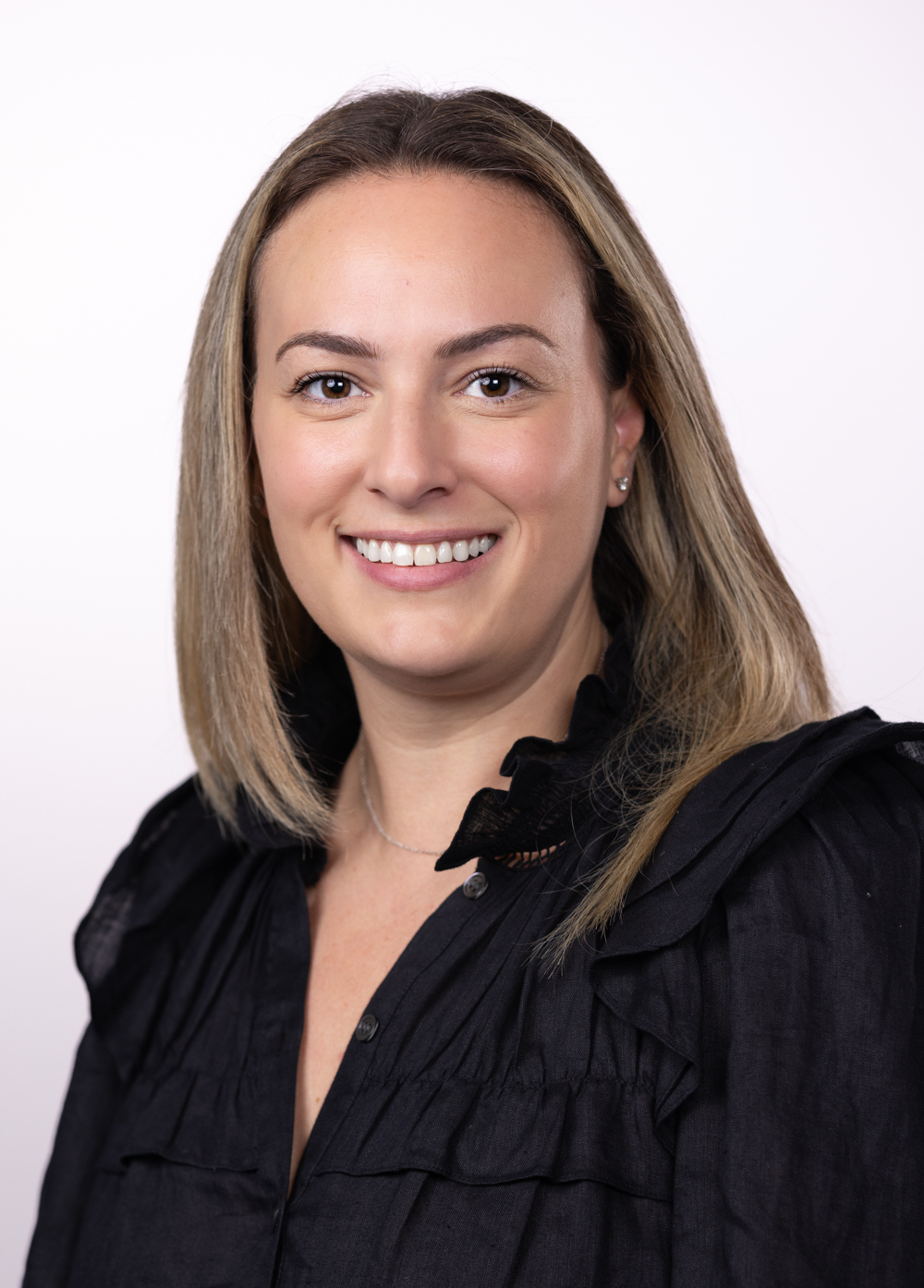 Social worker Kate Walsh, LCSW, wearing a black suit and smiling in front of a black background.