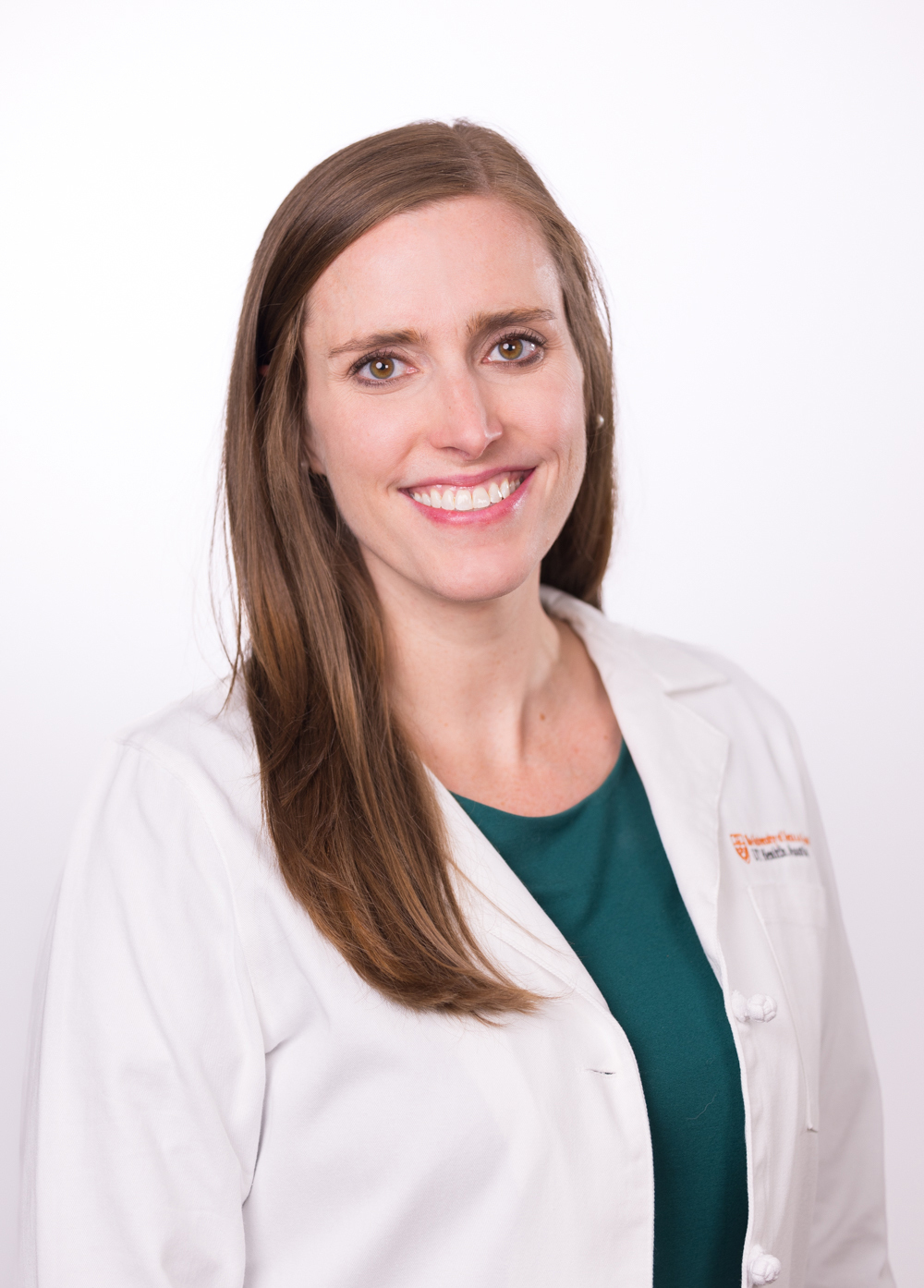 Dr. Lauren Caldwell wearing a white coat in and smiling front of a white backdrop.