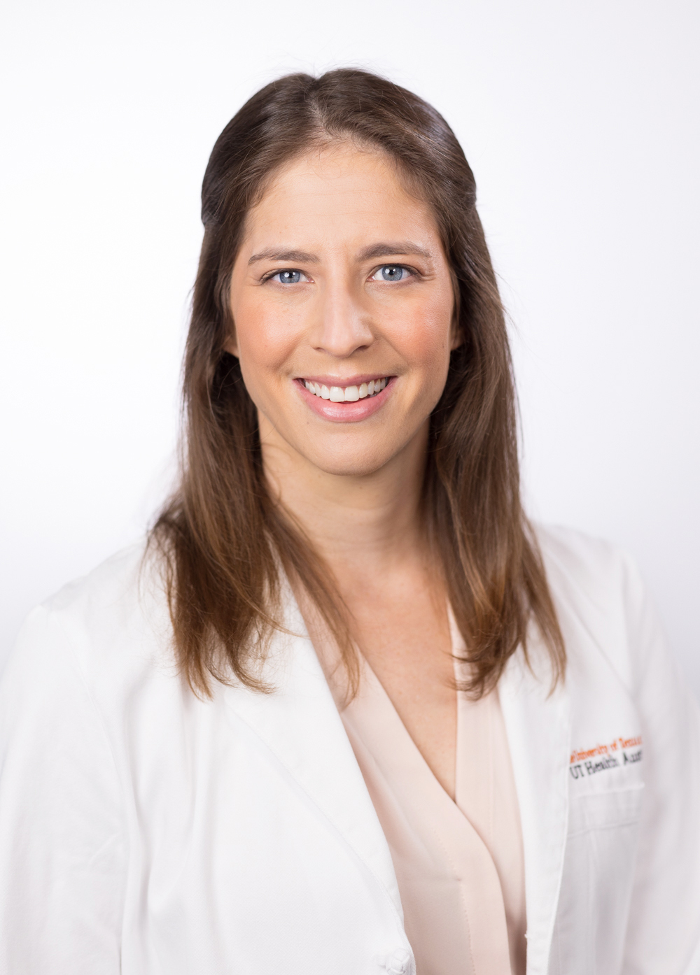 Dr. Lisa Boyars wearing a white coat and smiling in front of a white backdrop.