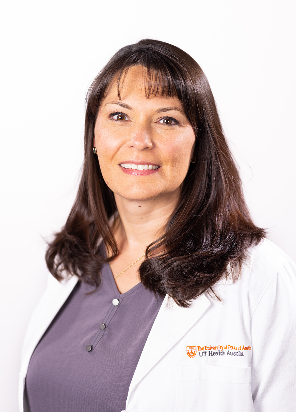 Family nurse practitioner Lisa Hadorn, MSN, APRN, FNP-C, wearing a white coat and smiling in front of a white backdrop.