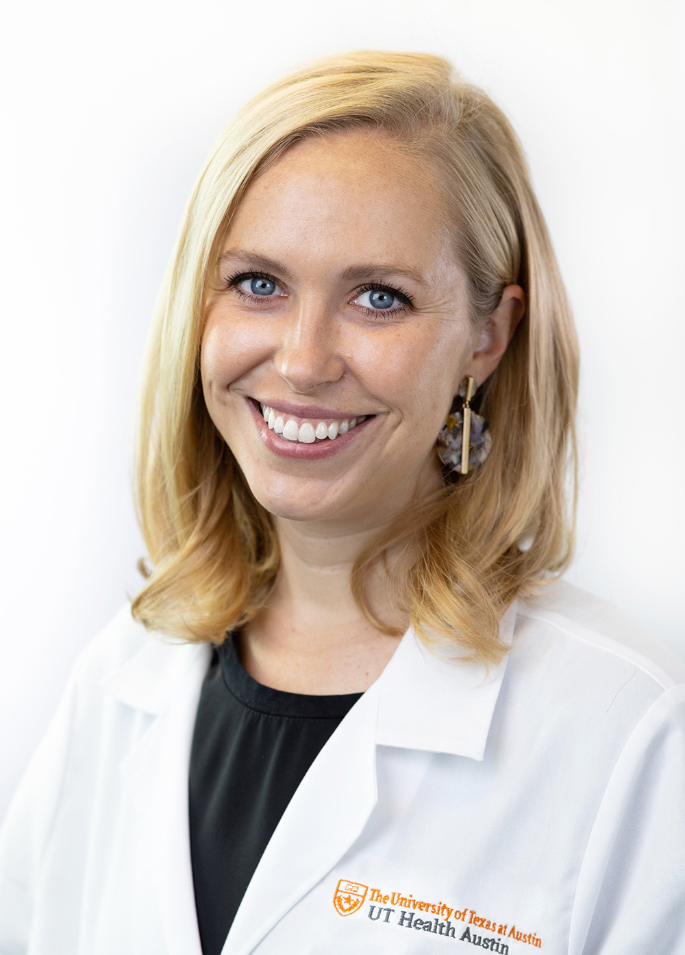 Fellowship-trained female pelvic medicine and reconstructive surgeon Mary Rieger, MD, MAS, wearing a white coat and smiling in front of a white backdrop.