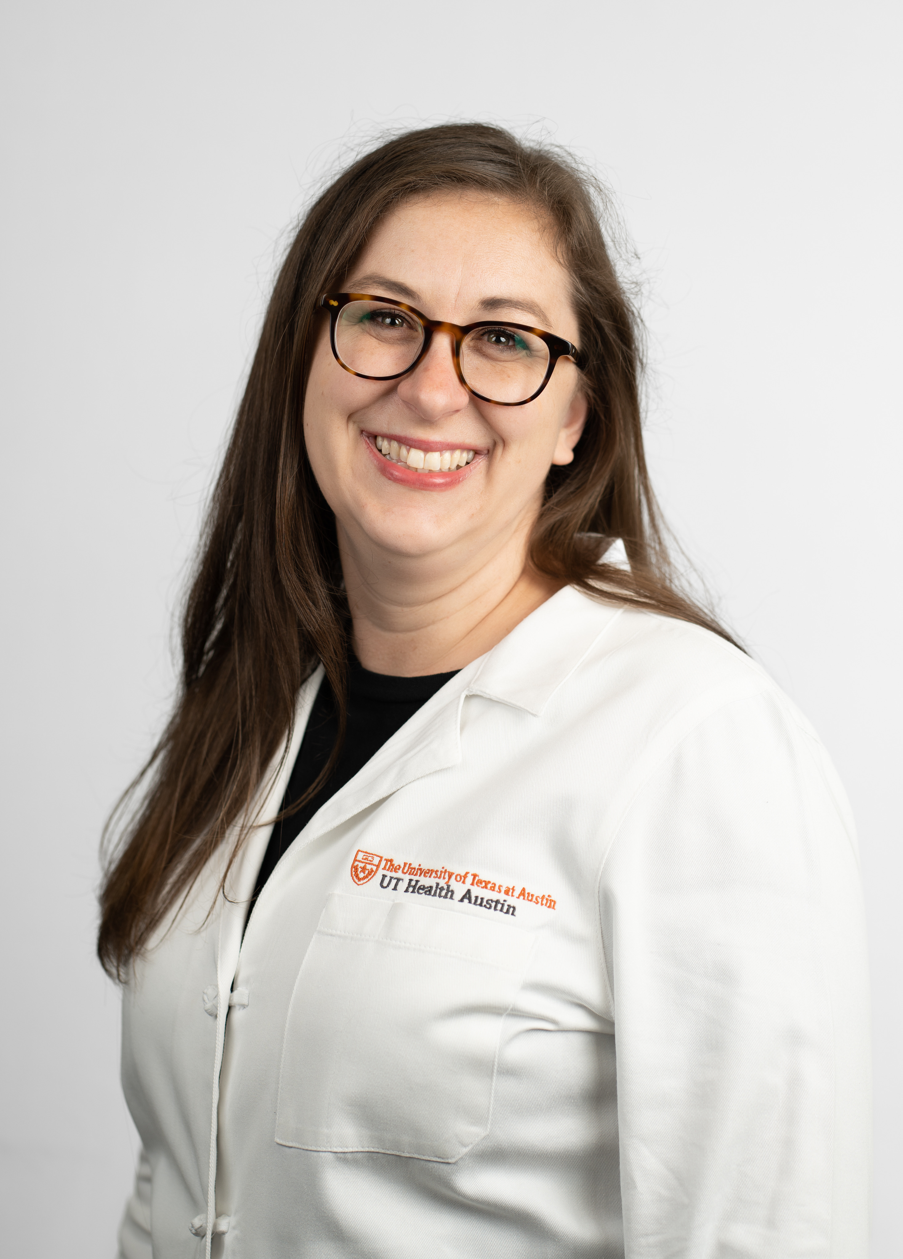Pediatric nurse practitioner Meghan Straub, MSN, APRN, CPNP-AC, wearing a white coat and smiling in front of a white backdrop.