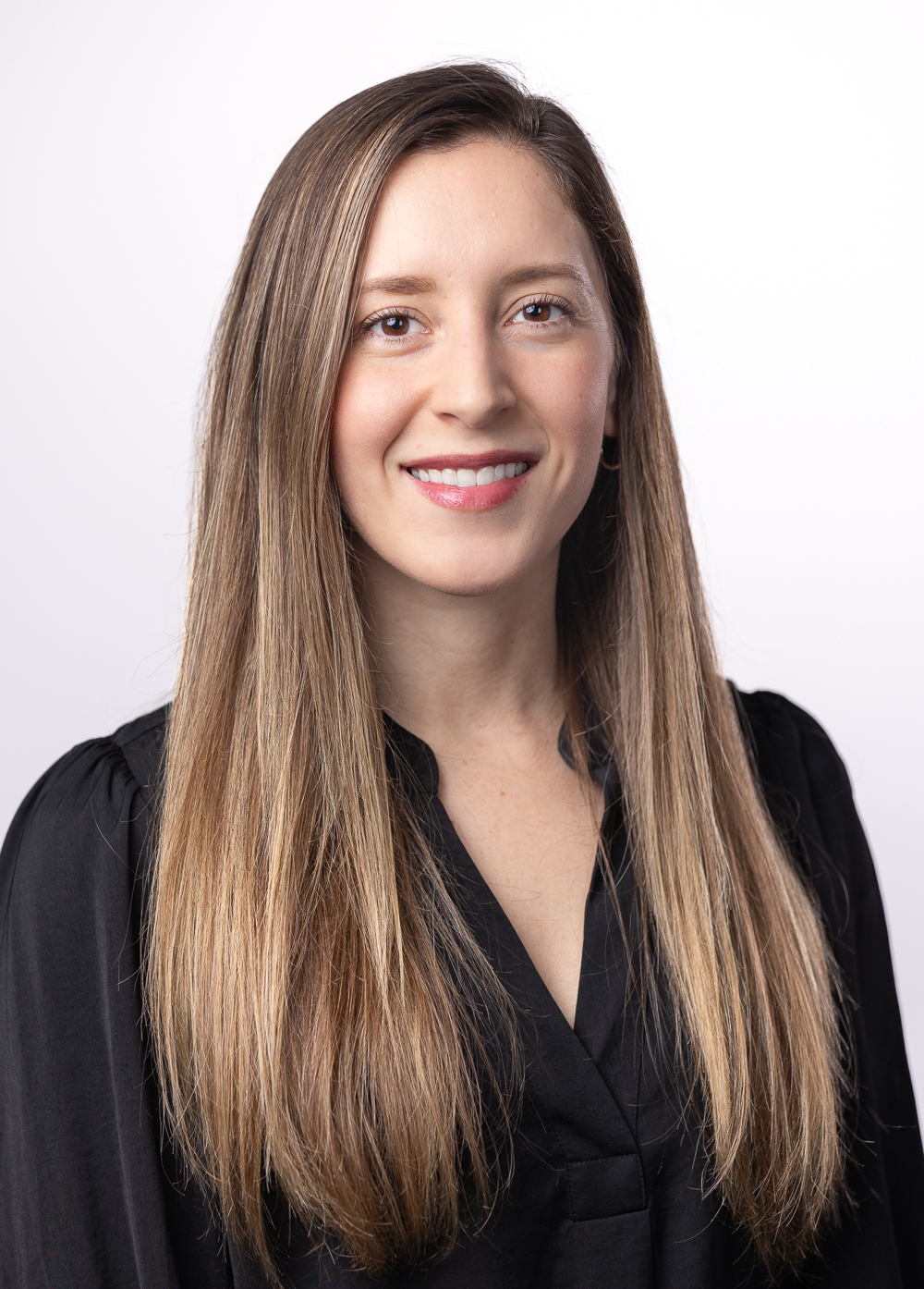 Social worker Melissa Barerra, LMSW, wearing a black blouse and smiling in front of a white backdrop.