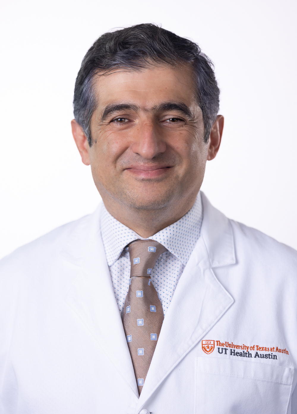 Gastroenterologist Mohammad Bashashati, MD, wearing a white coat and smiling in front of a white background.