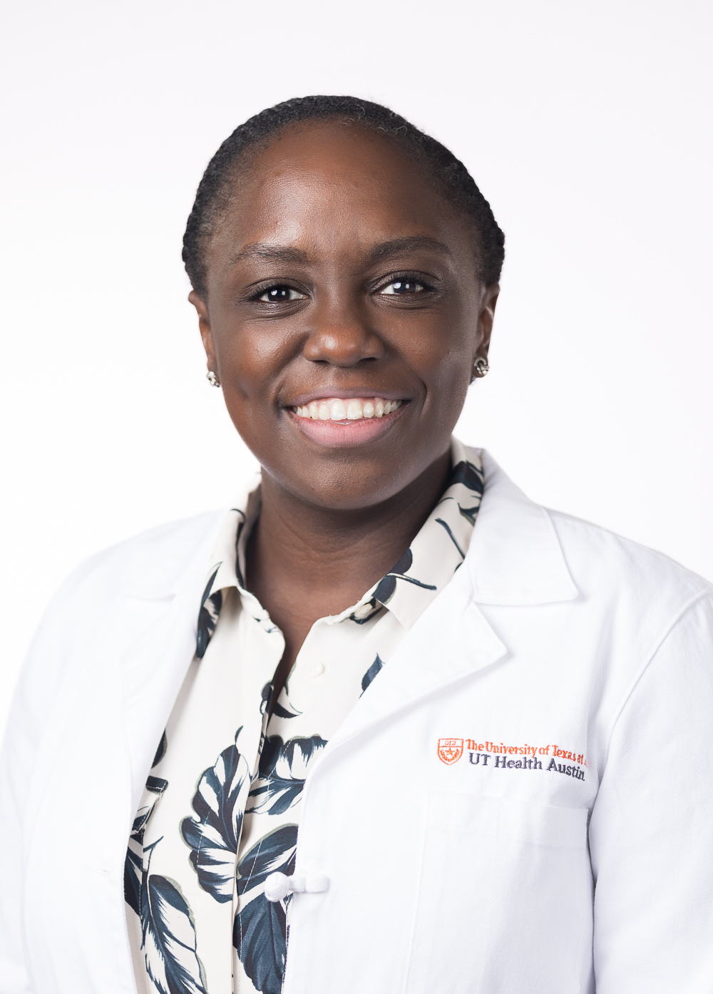 Gynecologic oncologist Nerlyne Desravines, MD, wearing a white coat and smiling in front of a white backdrop.