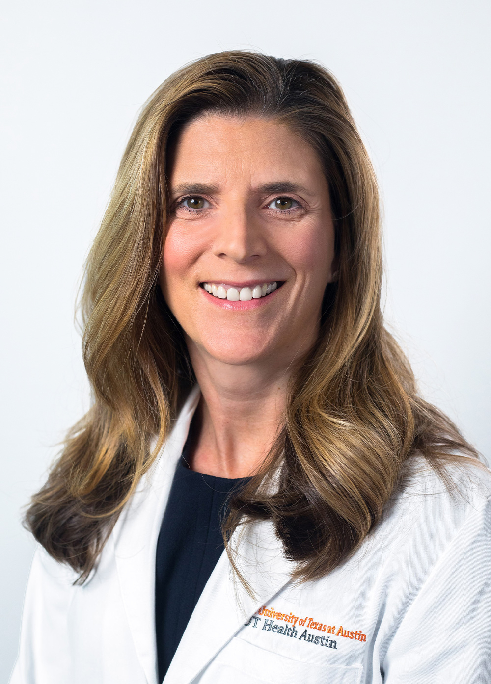 Abdominal transplant surgeon Nicole Turgeon, MD, FACS, wearing a white coat and smiling in front of a white backdrop.