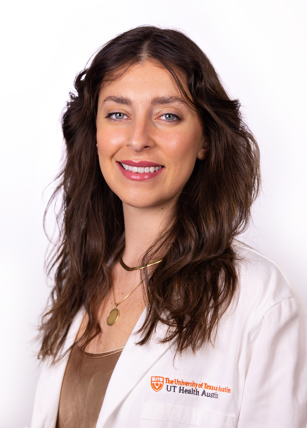 Dr. Rosalia Costello wearing a white coat and smiling in front of a white backdrop.