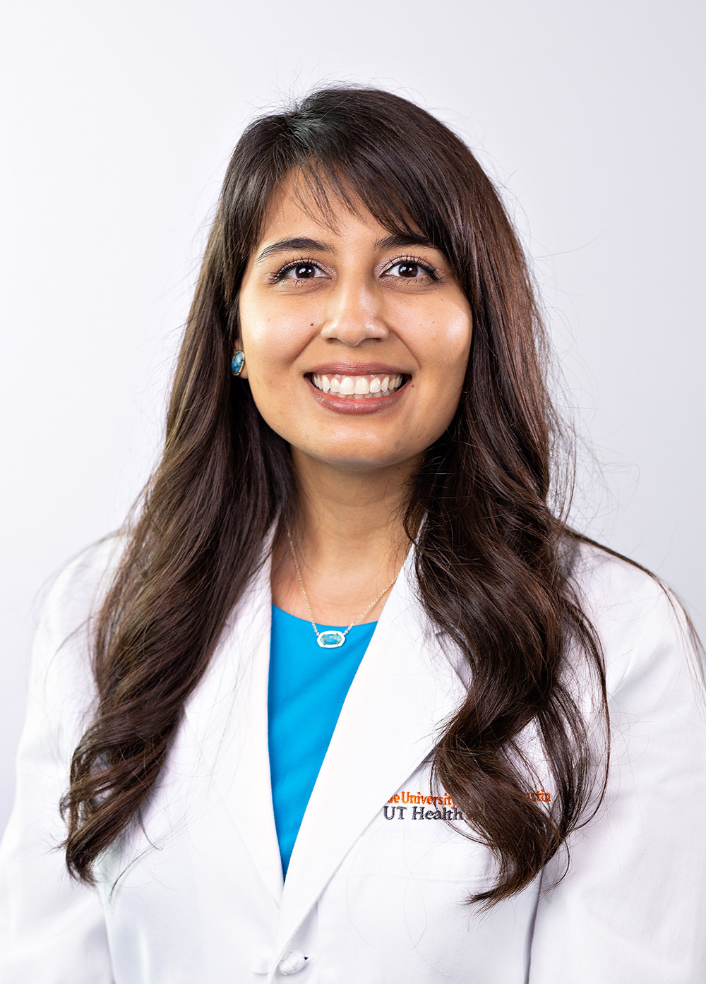 Obstetrician-gynecologist Ruby Ronquillo, MD, wearing a white coat and smiling in front of a white background.