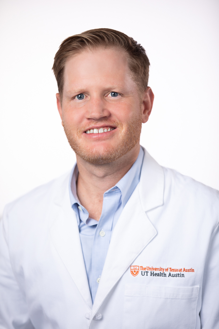 Surgeon Samuel E. "Rhett" Long, III, MD, FACS, wearing a white coat and smiling in front of a white backdrop.