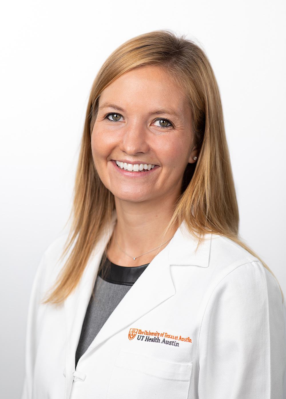 Pediatric neurologist Sara Pavitt, MD, wearing a white coat and smiling in front of a white backdrop.