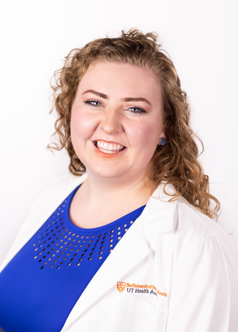 Family nurse practitioner Sarah Wilson Poole, MSN, APRN, FNP-C, wearing a white coat and smiling in front of a white backdrop.