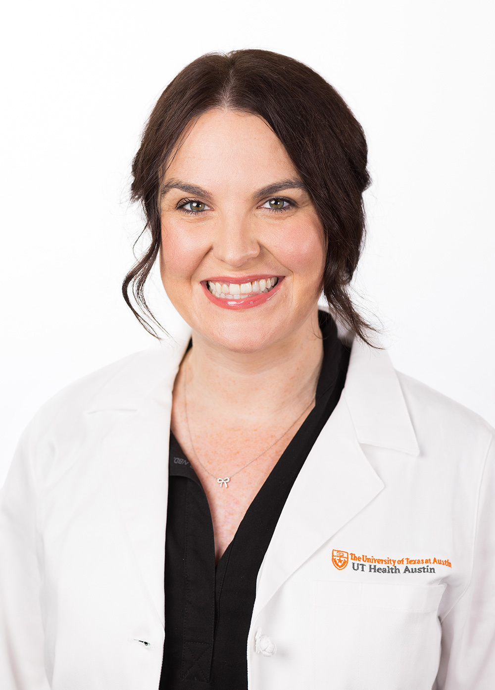 Acute care pediatric nurse practitioner Shae Clark, MSN, APRN, CPNP-AC, CCRN, wearing a white coat and smiling in front of a white backdrop.