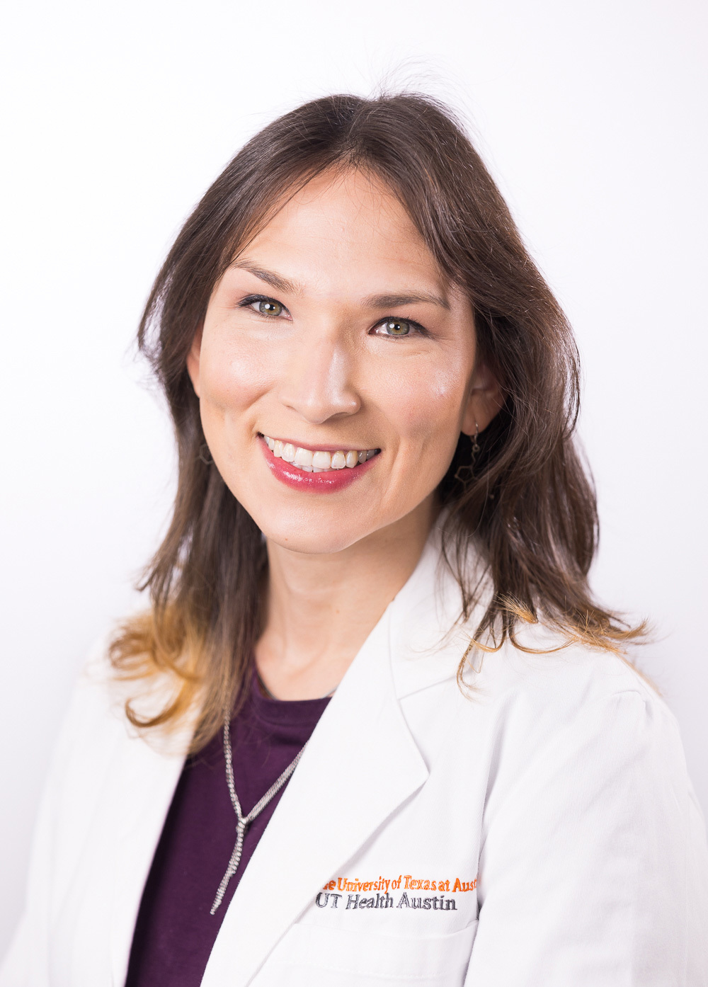 Dr. Victoria I. Felkl wearing a white coat and smiling in front of a white backdrop.