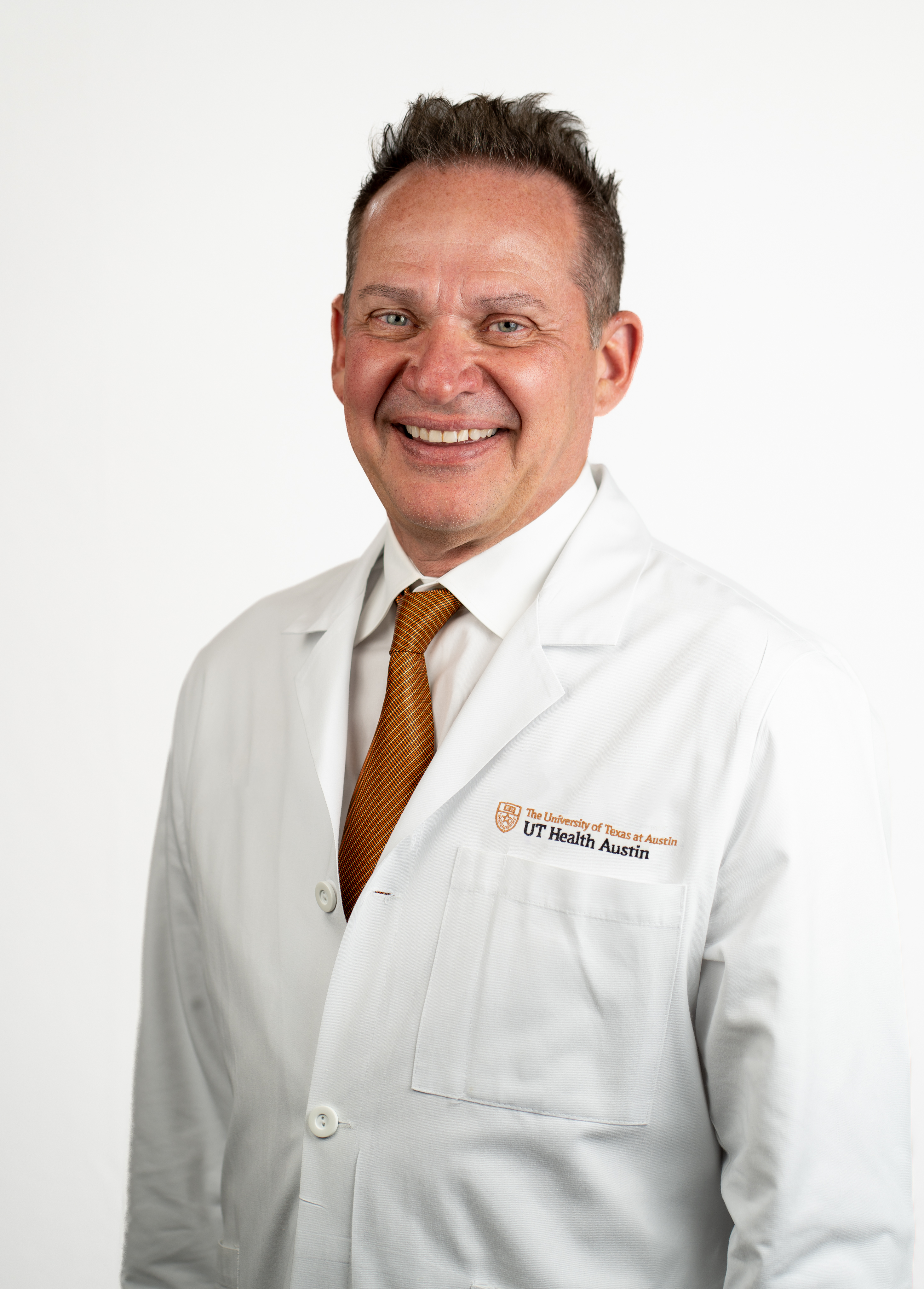 Cardiothoracic surgeon William Kessler, MD, FACS, wearing a white coat and smiling in front of a white backdrop.